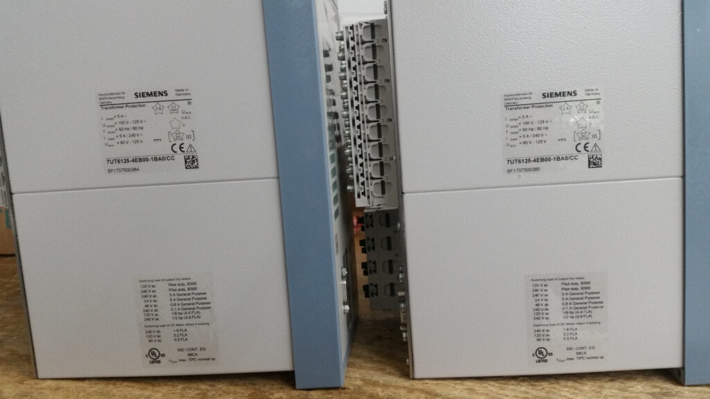 Rear view of Siemens SIPROTEC protection relays with labels and connection terminals for Potia Substation